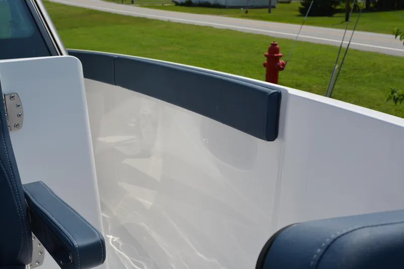 Slide: The Image of 2026 Monterey Elite 27 OB boat interior with blue and white seating, near a grassy area. - 14