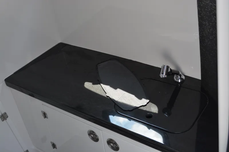 Slide: The Image of Black countertop with sink and faucet in 2026 Monterey Elite 27 OB boat. - 22