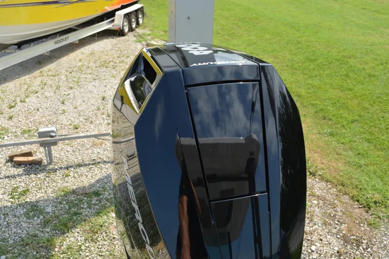 Slide: The Image of 2026 Monterey Elite 27 OB outboard engine, glossy black finish, parked on gravel near grass. - 7