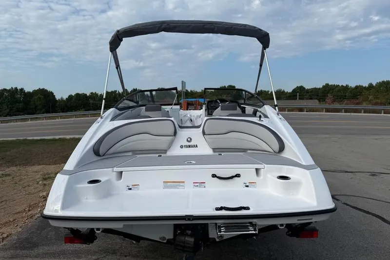 Slide: The Image of 2026 Yamaha Boats SX190, sleek white design, parked on a road with trees in background. - 5