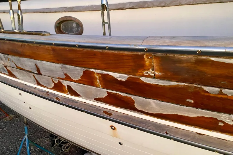 Slide: The Image of Weathered wooden hull of 1991 Hans Christian 41 T Molakai sailboat, showing peeling varnish. - 117
