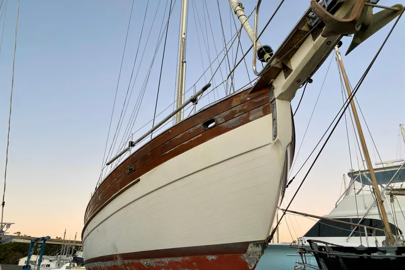 Slide: The Image of Sailboat Hans Christian 41 T Molakai 1991 in dry dock, showcasing wooden hull details. - 13