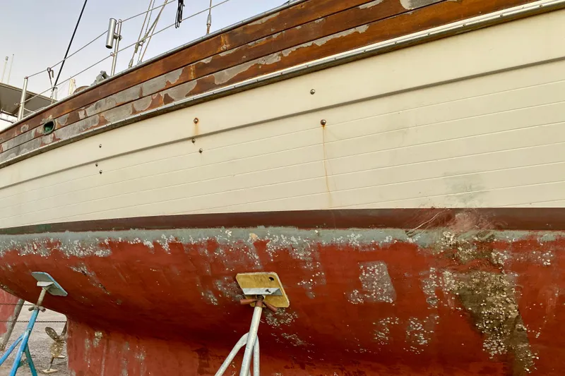 Slide: The Image of 1991 Hans Christian 41 T Molakai sailboat on stands, showing weathered hull and deck. - 18