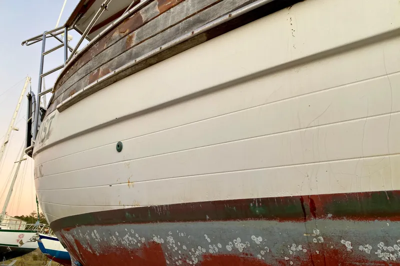 Slide: The Image of 1991 Hans Christian 41 T Molakai sailboat with weathered hull and visible rust. - 23