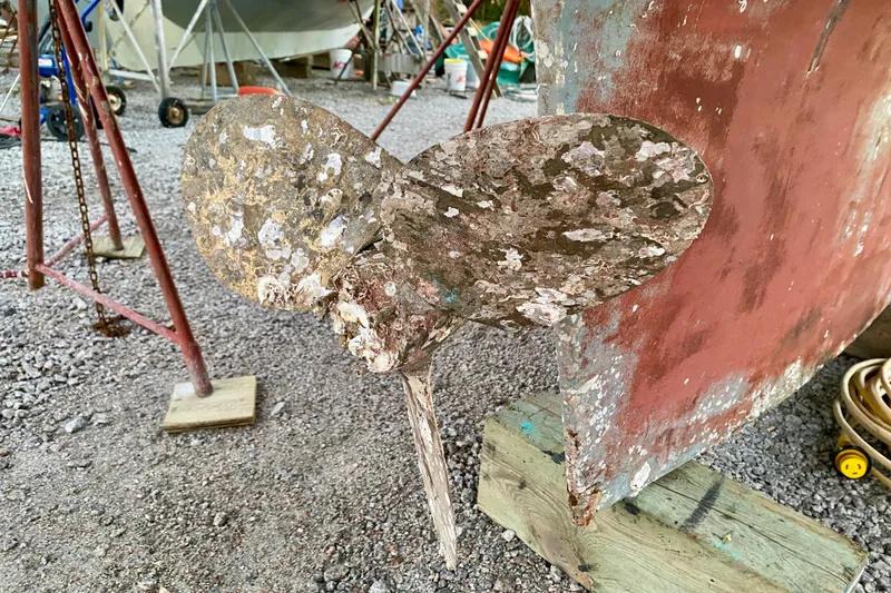 Slide: The Image of Weathered propeller of 1991 Hans Christian 41 T Molakai sailboat on gravel. - 24