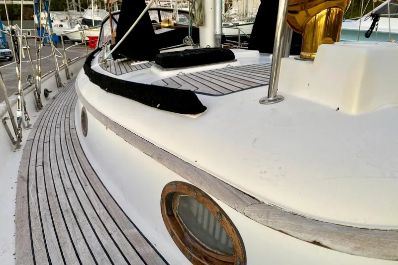 Slide: The Image of Deck view of 1991 Hans Christian 41 T Molakai sailboat, showcasing wooden details and porthole. - 32