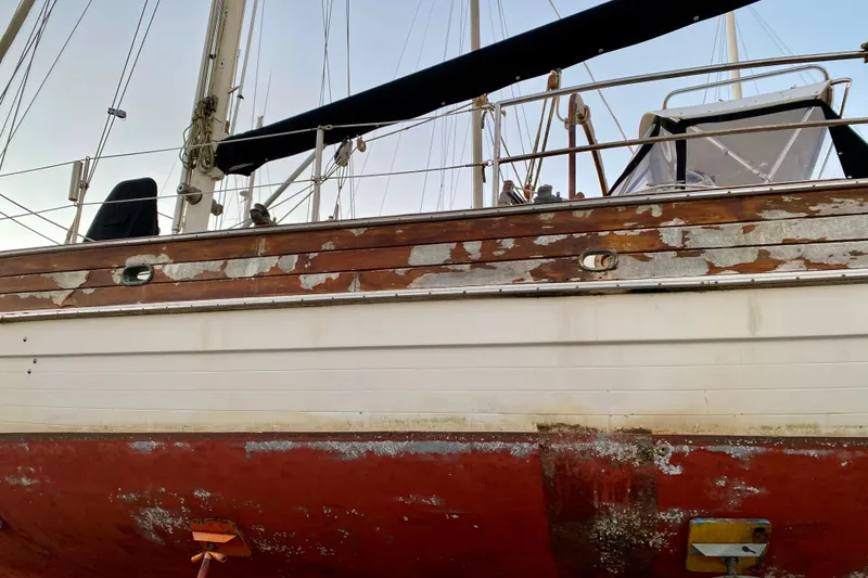 Slide: The Image of 1991 Hans Christian 41 T Molakai sailboat with weathered hull and peeling paint. - 5