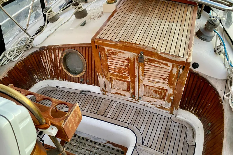 Slide: The Image of 1991 Hans Christian 41 T Molakai sailboat cockpit with weathered wood and nautical equipment. - 53