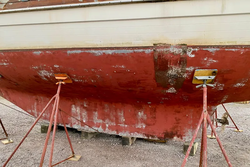 Slide: The Image of 1991 Hans Christian 41 T Molakai sailboat hull on stands, showing wear and weathering. - 6