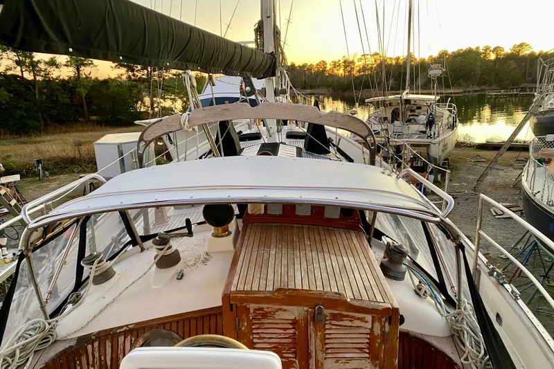 Slide: The Image of 1991 Hans Christian 41 T Molakai sailboat docked at sunset, surrounded by trees and water. - 60