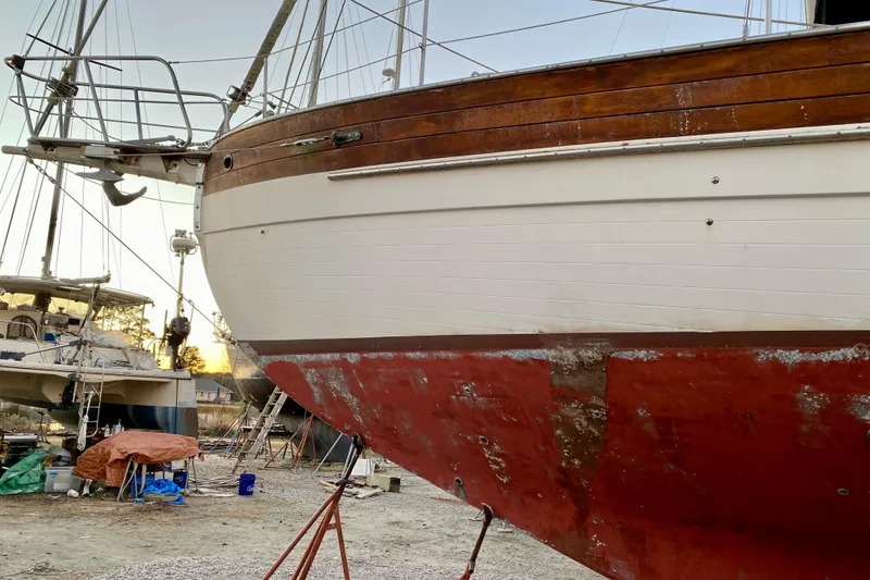 Slide: The Image of Sailboat Hans Christian 41 T Molakai 1991 in dry dock, showing weathered hull and wooden details. - 7