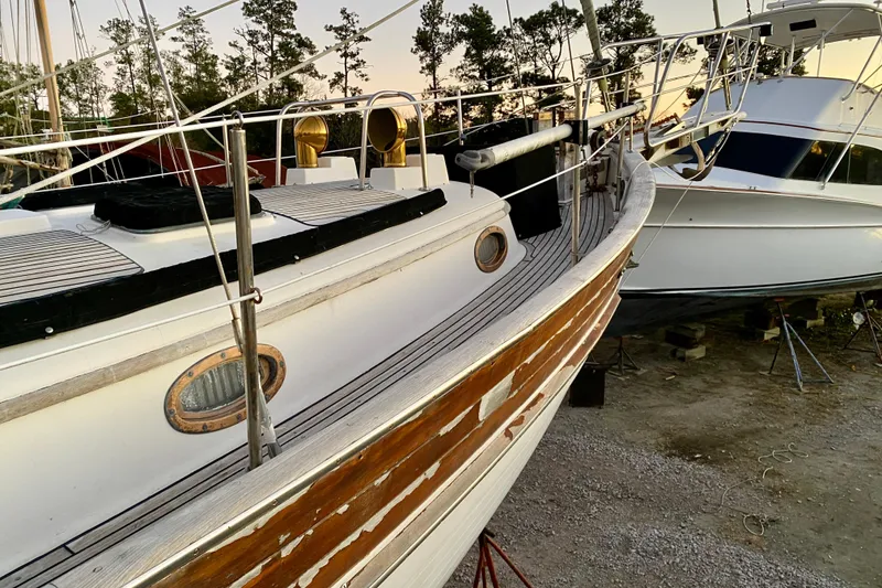 Slide: The Image of Sailboat Hans Christian 41 T Molakai 1991 on dry dock, surrounded by trees and another boat. - 85