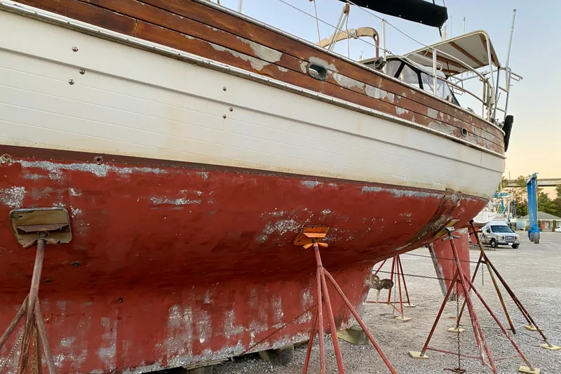 Slide: The Image of 1991 Hans Christian 41 T Molakai sailboat on stands, showing weathered hull and deck. - 9