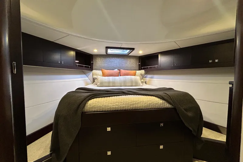 Slide: The Image of Luxurious bedroom interior of 2021 Palm Beach Motor Yachts GT60, featuring elegant bedding and cabinetry. - 22