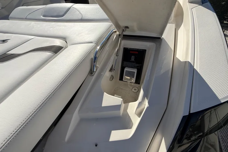 Slide: The Image of 2014 Monterey 328SS Super Sport boat with open storage compartment and white seating. - 10