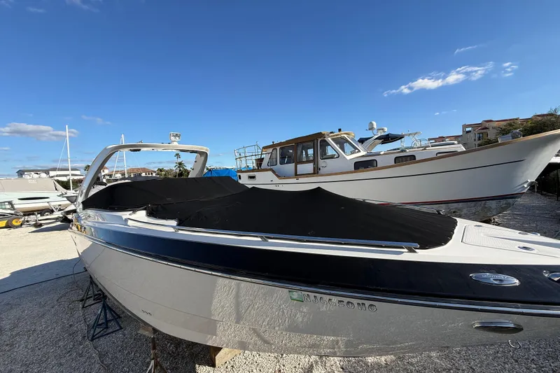 Slide: The Image of 2014 Monterey 328SS Super Sport boat with cover, docked under clear blue sky. - 101