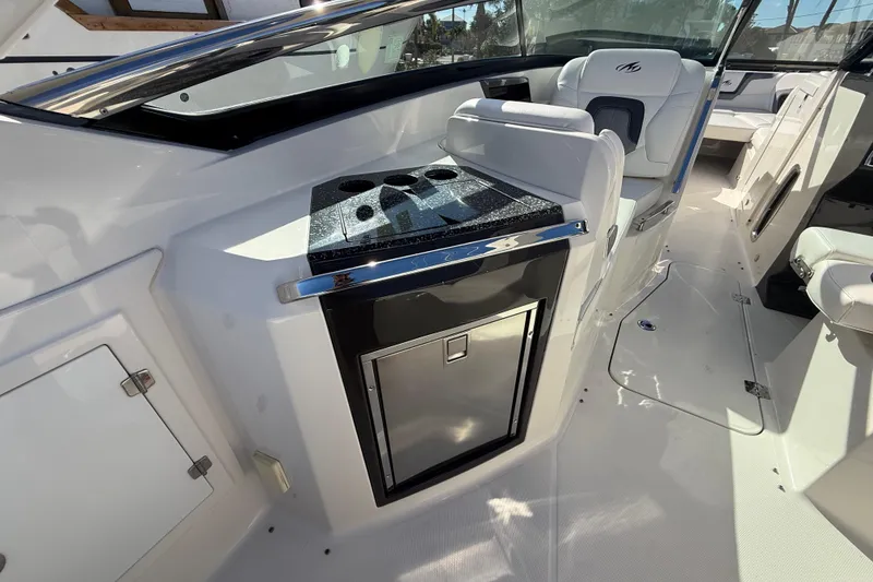 Slide: The Image of 2014 Monterey 328SS Super Sport boat interior with seating and kitchenette area. - 14