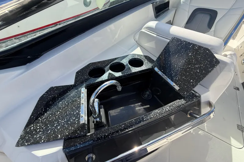 Slide: The Image of 2014 Monterey 328SS Super Sport boat interior with sink and cup holders. - 16