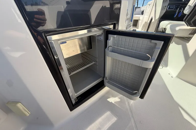 Slide: The Image of Open mini fridge on 2014 Monterey 328SS Super Sport boat, showcasing interior storage space. - 18