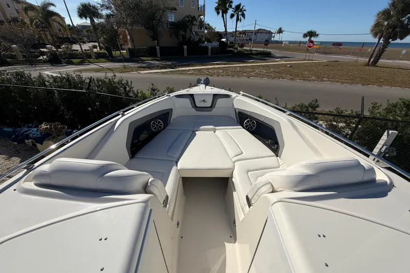 Slide: The Image of 2014 Monterey 328SS Super Sport boat with spacious white seating and coastal view. - 56