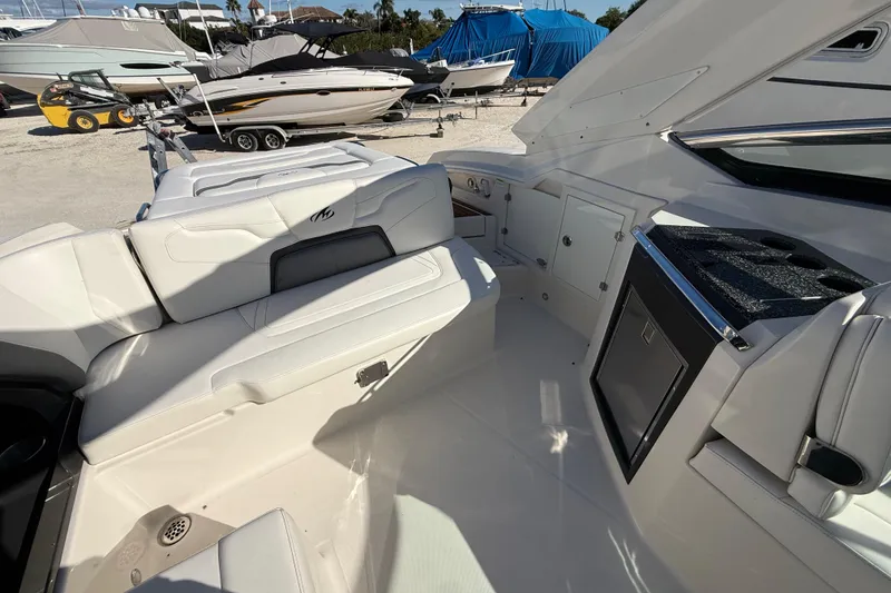 Slide: The Image of 2014 Monterey 328SS Super Sport boat interior with white seating and storage compartments. - 85