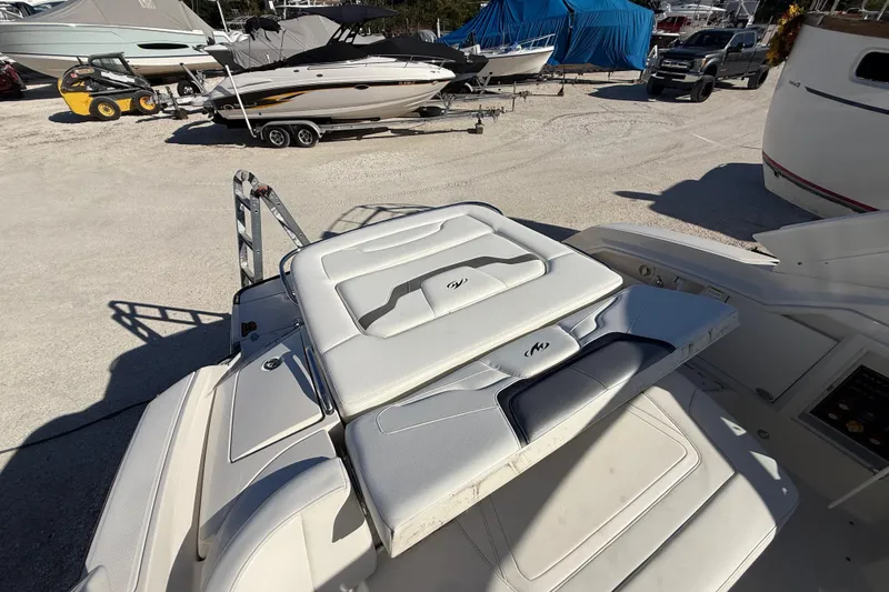 Slide: The Image of 2014 Monterey 328SS Super Sport boat interior with cushioned seating in a marina setting. - 93