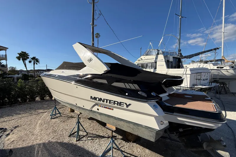 Slide: The Image of 2014 Monterey 328SS Super Sport boat on stands, marina background, sunny day. - 97