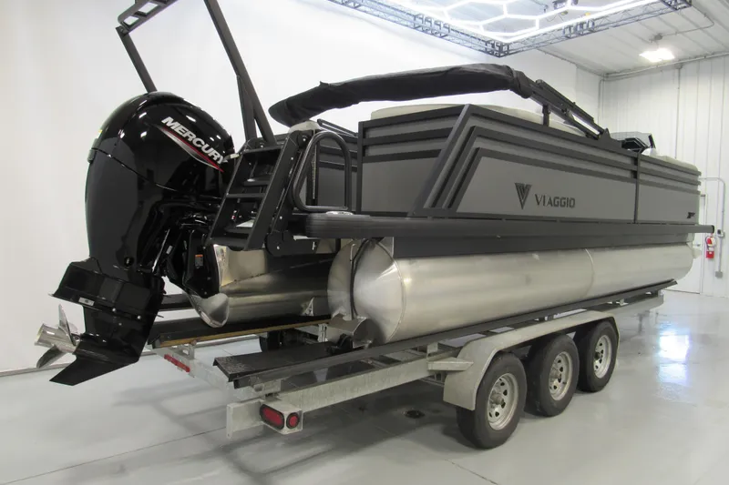 Slide: The Image of 2026 Viaggio Lago X22U pontoon boat on trailer in indoor showroom. - 2