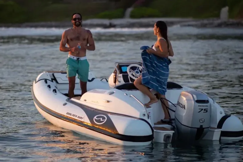 Slide: The Image of Walker Bay Generation 15 boat, 2026 model, with two people enjoying a sunset cruise. - 4