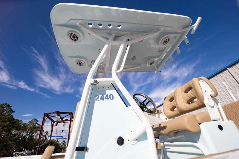 Slide: The Image of 2026 Blazer Bay 2440 boat with T-top and cushioned seating under clear blue sky. - 1