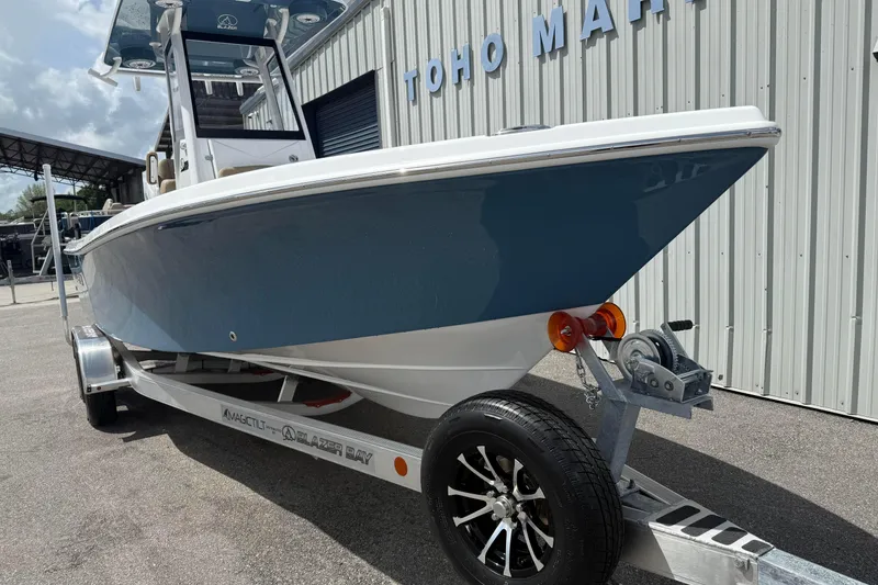 Slide: The Image of 2026 Blazer Bay 2440 boat on trailer at marina, side view. - 12