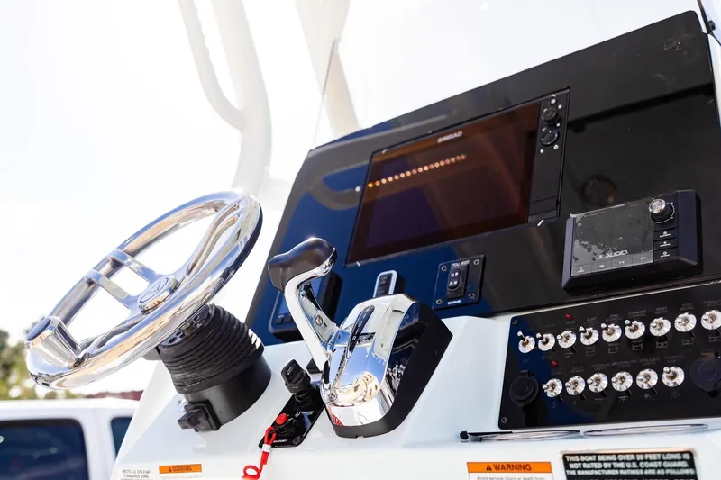 Slide: The Image of Control panel of 2026 Blazer Bay 2440 boat with steering wheel and electronic displays. - 2