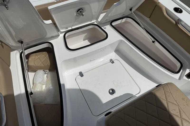 Slide: The Image of Interior storage compartments of a 2026 Blazer Bay 2440 boat, featuring cushioned seating. - 21