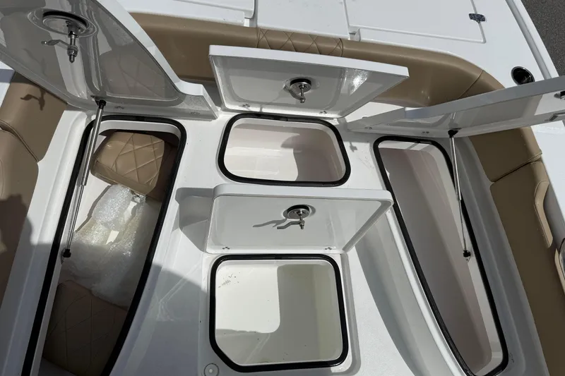 Slide: The Image of 2026 Blazer Bay 2440 boat storage compartments with open hatches and cushioned seating. - 22