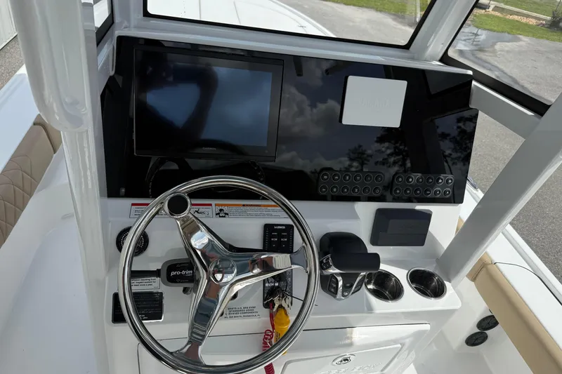 Slide: The Image of 2026 Blazer Bay 2440 boat dashboard with steering wheel and electronic controls. - 26