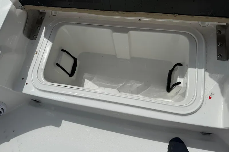 Slide: The Image of Open storage compartment in 2026 Blazer Bay 2440 boat, featuring white interior and black handles. - 35