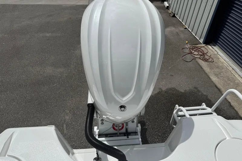 Slide: The Image of 2026 Blazer Bay 2440 boat engine, white exterior, parked on asphalt near storage facility. - 38