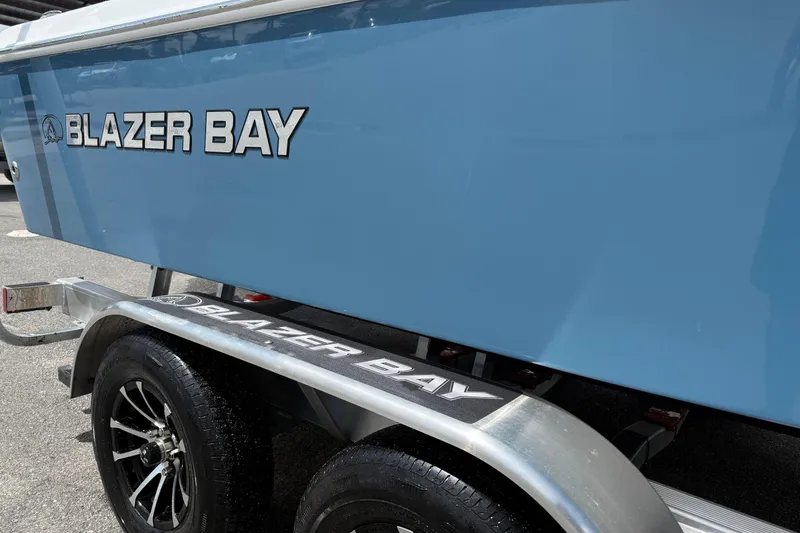 Slide: The Image of 2026 Blazer Bay 2440 boat on trailer, showcasing sleek blue design and branding. - 7