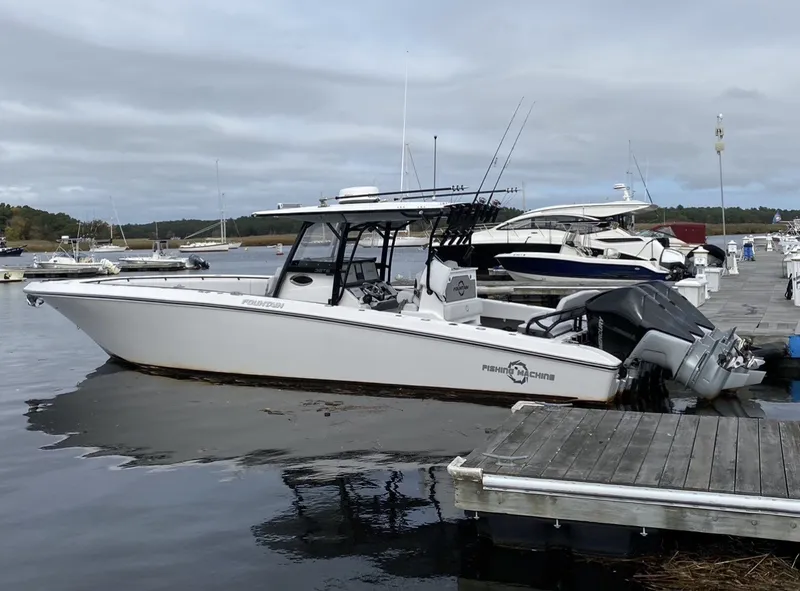 Slide: The Image of A 2021 Fountain 38 Tournament Edition boat docked. It features a sleek white hull design. - 12