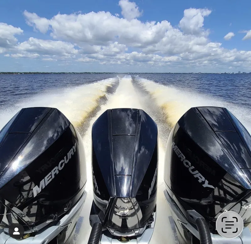 Slide: The Image of Three powerful Mercury outboard engines propel a boat across open water. - 0