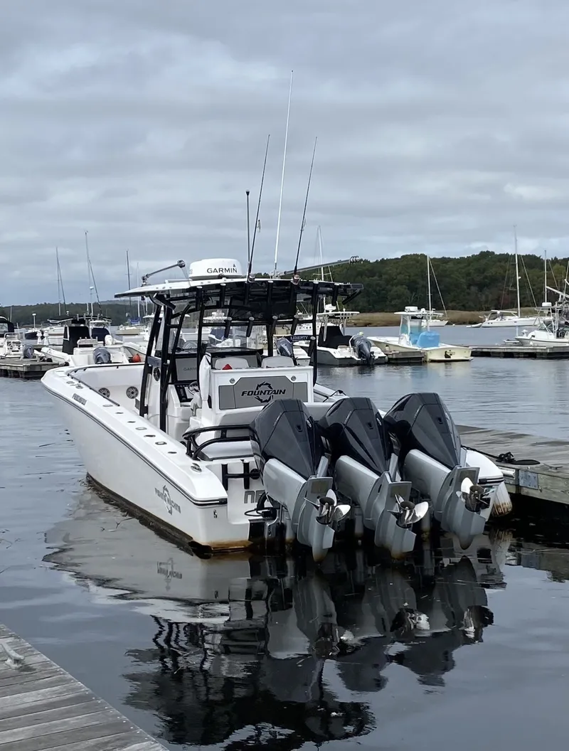 Slide: The Image of A 2021 Fountain 38 Tournament Edition boat docked, featuring three outboard engines. - 11
