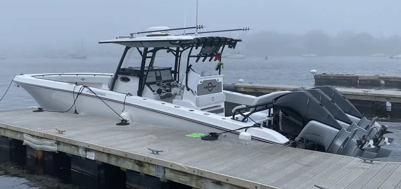 Slide: The Image of A 2021 Fountain 38 Tournament Edition boat docked in foggy conditions, featuring three outboard engines. - 7