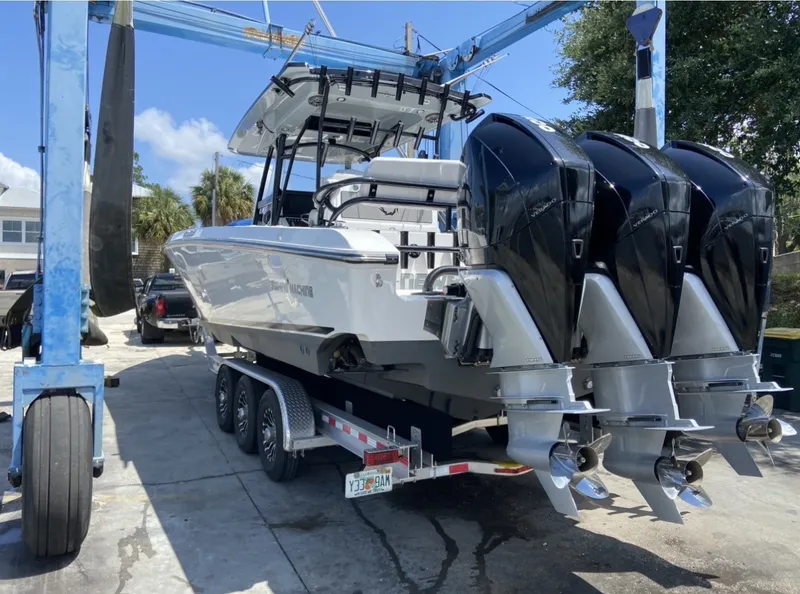 Slide: The Image of A 2021 Fountain 38 Tournament Edition boat on a trailer with three outboard engines. - 4