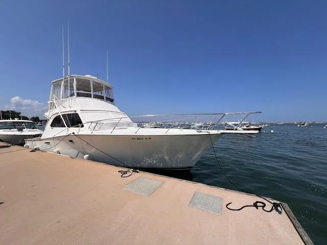 Slide: The Image of 1985 Post 43 Convertible yacht docked at marina under clear blue sky. - 4