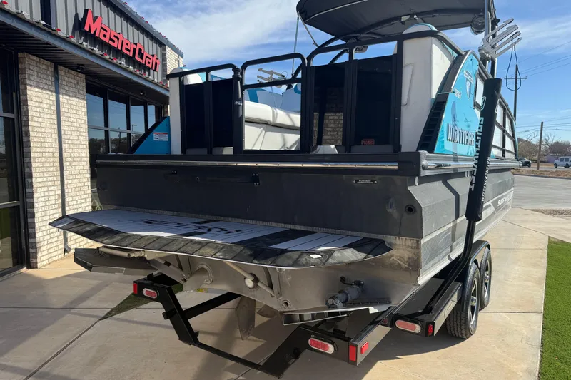 Slide: The Image of 2020 Montara Surf Boss boat on trailer outside MasterCraft dealership. - 13