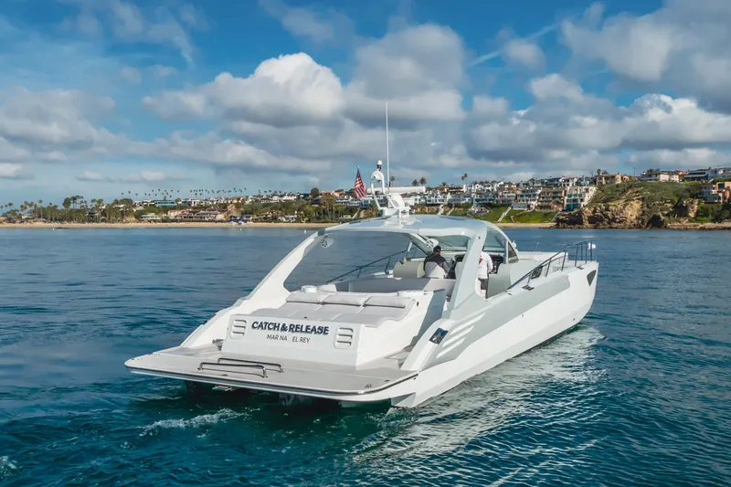 Slide: The Image of Custom 60 yacht cruising near coastal homes, 2017 model, under a partly cloudy sky. - 2