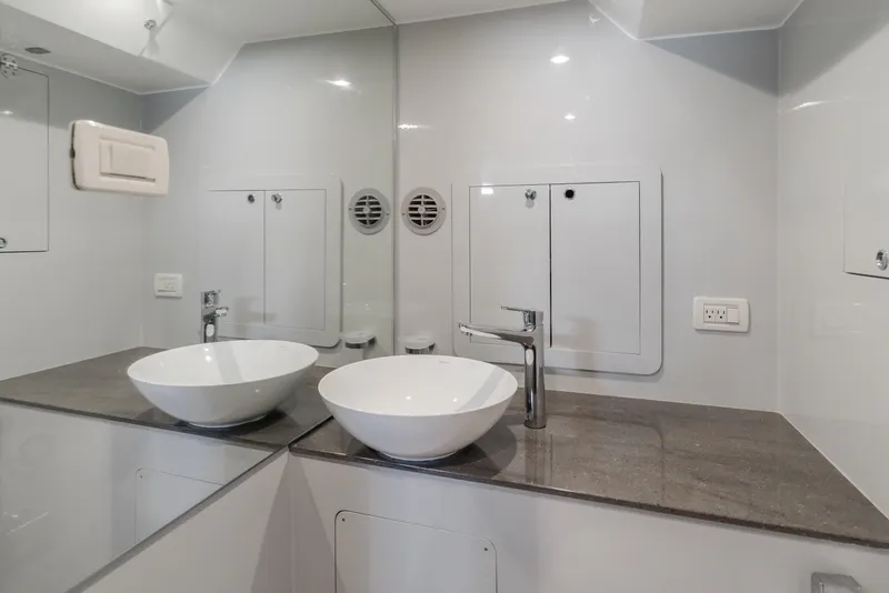 Slide: The Image of Modern bathroom with vessel sink, sleek faucet, and mirrored walls in a Custom 60, 2017 model. - 26