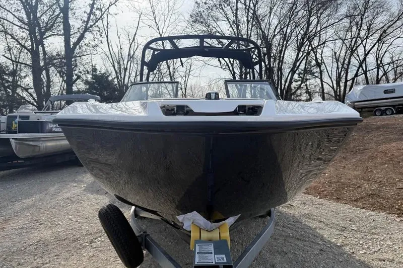 Slide: The Image of 2026 Yamaha Boats AR250 on trailer, parked outdoors with trees in background. - 2
