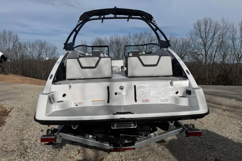 Slide: The Image of 2026 Yamaha Boats AR250, rear view, on a trailer, outdoors with trees in background. - 7