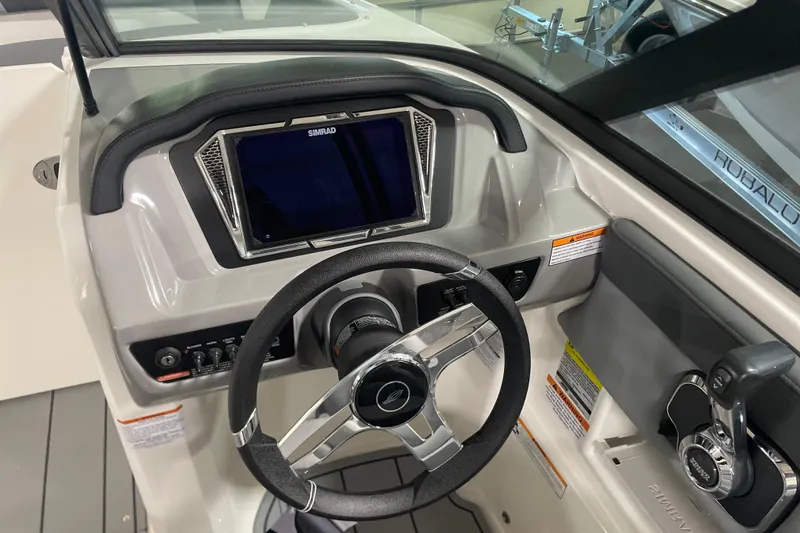 Slide: The Image of 2026 Chaparral 23 SSi boat dashboard with steering wheel and Simrad display. - 2